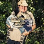 Mujer con dos cocodrilos vestidos de bebés