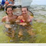 Foto graciosa de un pez manta jodefotos y dos chicas bañándose en el mar